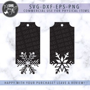 Op de afbeelding: Twee zwarte rechthoekige labels met een uitgesneden sneeuwvlokontwerp aan de onderkant. De labels hebben een klein gaatje aan de bovenkant. Tekst op de afbeelding is onder meer "SVG-DXF-EPS-PNG" en "COMMERCIAL USE FOR PHYSICAL ITEMS". De onderkant van de afbeelding zegt "HAPPY WITH YOUR PURCHASE? LEAVE A REVIEW!"