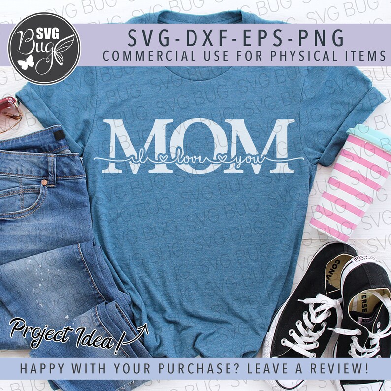 May include: A blue t-shirt with the text "MOM I love you" in white. The shirt is laid out on a table with a pair of jeans, a pink and white striped cup, and a pair of black sneakers.