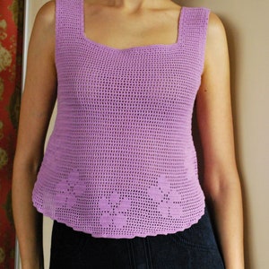 May include: A light purple crochet tank top with a square neckline and a scalloped hem.