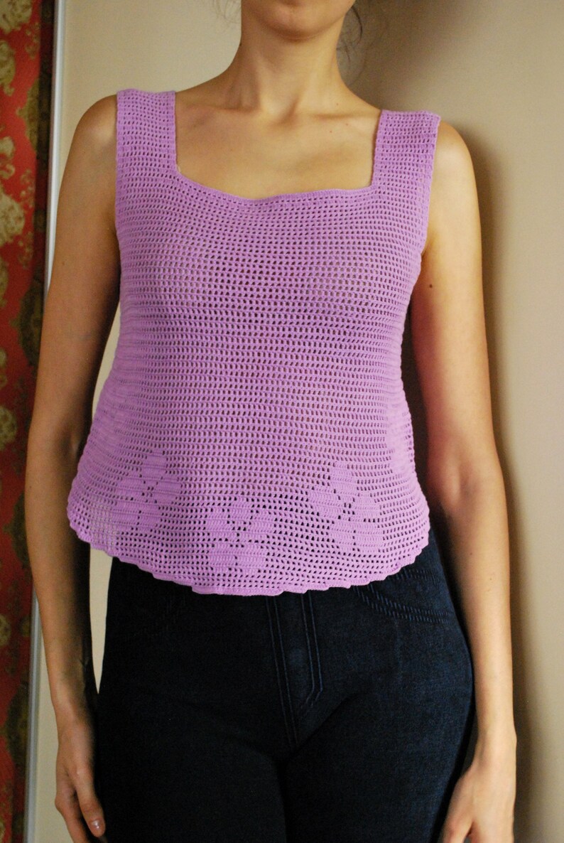 May include: A light purple crochet tank top with a square neckline and a scalloped hem.