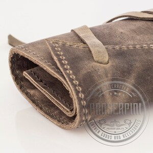 May include: A brown leather roll-up case with a strap closure. The case is hand-crafted and features the text "Proserpio Leather Goods and Accessories" in a circle.