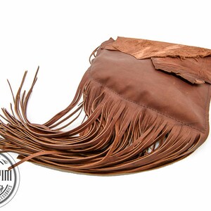 May include: A brown leather handbag with fringe detailing. The bag has a flap closure and a brown leather strap.