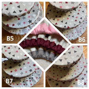 May include: Set of four reusable food covers in various patterns. The covers are made of fabric with a gray background and feature different designs, including stars, triangles, and polka dots. The covers are stacked on top of each other, with the largest cover on the bottom and the smallest cover on top.