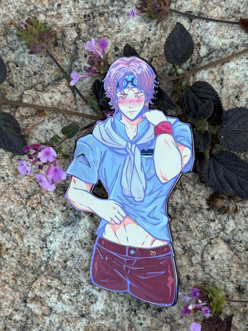 K&ouml;nnte beinhalten: Ein farbenfroher Emaille-Pin mit einem Anime-Charakter mit lila Haaren, einem blauen Stirnband und einem blauen Hemd. Die Figur tr&auml;gt weinrote Shorts mit einem Herzdetail. Der Pin ist vor einem Naturstein-Hintergrund mit lila Blumen platziert.