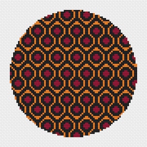 May include: A circular pattern with a repeating design of black, orange, and red hexagons. The pattern is reminiscent of a carpet or rug.