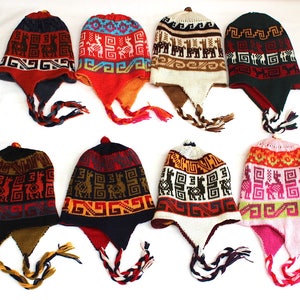 May include: Eight colorful knit hats with ear flaps and braided ties. The hats feature geometric patterns and llama designs in various colors, including red, blue, green, and pink. The hats are displayed on a white surface.