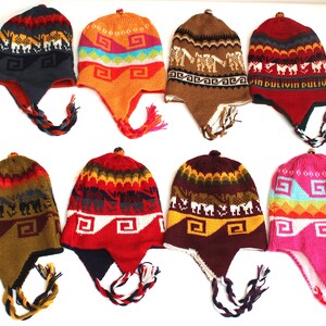 May include: A collection of eight colorful knit hats with ear flaps and braided tassels. The hats feature geometric and animal patterns in various colors, including red, orange, blue, and brown. Each hat has a small pom-pom on top.