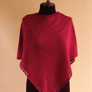 Pode incluir: Um poncho de malha bord&ocirc; com uma borda de croch&ecirc;. O poncho &eacute; exibido em um manequim.