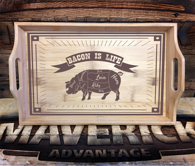May include: A wooden serving tray with a brown border and a pig illustration. The pig is labeled with different cuts of meat, including "Bacon is Life". The tray is made by Maverick Advantage.