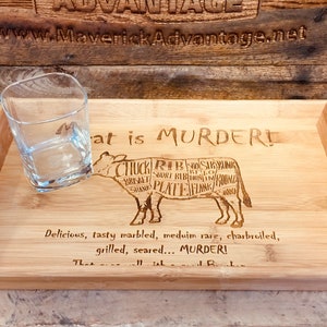 May include: A wooden serving tray with a cow cut-out design and the text "Meat is Murder!"  The cow is labeled with different cuts of meat. The tray has two handles on the sides.