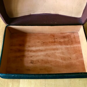 May include: An empty, black leather box with a brown leather interior. The box is open and the interior is visible.