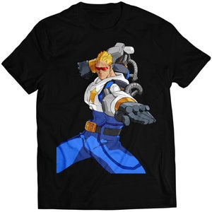 May include: A black t-shirt featuring a cartoon character in a blue and white suit with red goggles, holding a large mechanical arm.