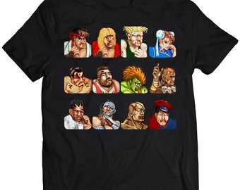 May include: Black t-shirt with a grid of pixelated character portraits. The characters, from a fighting game, display distinct facial expressions and outfits. The design is a vibrant, retro-style graphic.