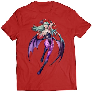 May include: Red t-shirt with a graphic print of a female character with purple wings and green hair. The character is wearing a purple and pink outfit.