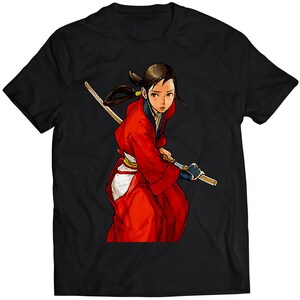 Könnte beinhalten: Ein schwarzes T-Shirt mit einer bunten Illustration einer Frau in einem roten Kimono, die ein Schwert hält. Die Frau hat langes schwarzes Haar und schaut zur Seite.