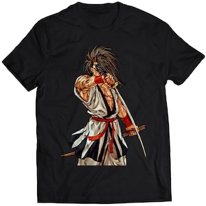 Könnte beinhalten: Ein schwarzes T-Shirt mit einem Aufdruck eines Samurai-Kriegers, der ein Schwert hält. Der Samurai trägt eine weiße und schwarze Robe mit einem roten Gürtel.