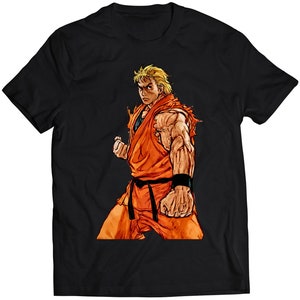 Könnte beinhalten: Ein schwarzes T-Shirt mit einem Aufdruck eines blonden Mannes in einem orangefarbenen Karate-Gi mit einem schwarzen Gürtel und einem entschlossenen Gesichtsausdruck.