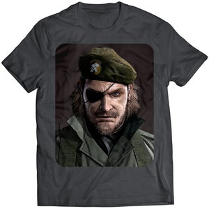 May include: A dark grey t-shirt featuring a printed image of a man wearing a green beret and a camouflage jacket. The man has a beard and an eyepatch.