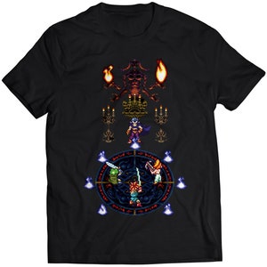 Puede incluir: Camiseta negra con un diseño pixelado de una escena de un videojuego de fantasía. El diseño presenta una figura oscura con una espada, una criatura verde y un monstruo rojo con llamas.
