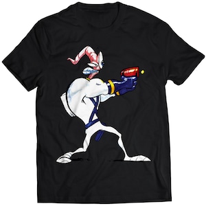 Pode incluir: Camiseta preta com uma ilustração de desenho animado de um personagem rosa e branco segurando um blaster vermelho e azul.