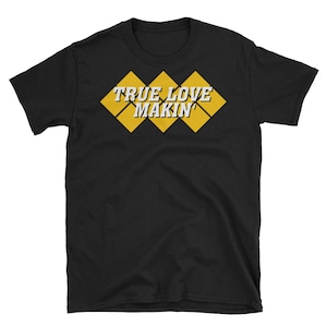 Könnte beinhalten: Schwarzes T-Shirt mit einem gelben Diamantenmuster und dem Text "True Love Makin'" in Weiß.