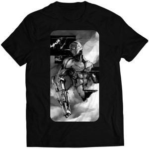 Op de afbeelding: Zwart-wit T-shirt met een grafische afbeelding van een gemaskerd figuur dat een wapen vasthoudt. De figuur is omgeven door een rookwolk.