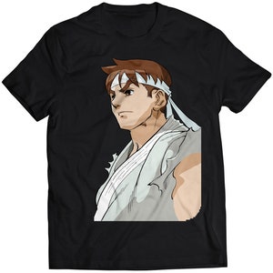 Op de afbeelding: Een zwart T-shirt met een witte en grijze illustratie van een man met bruin haar die een wit hoofdband draagt. De man kijkt naar rechts.