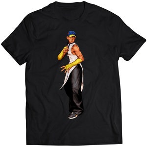 Könnte beinhalten: Schwarzes T-Shirt mit einer Cartoon-Illustration eines Mannes, der eine blaue und gelbe Baseballkappe, ein weißes ärmelloses Hemd und gelbe Handschuhe trägt. Der Mann befindet sich in Kampfstellung.