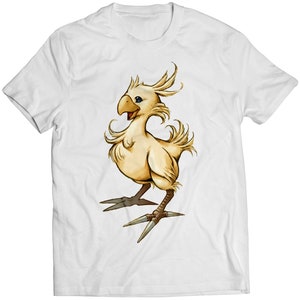 May include: White t-shirt featuring a cartoon image of a yellow, fluffy, bird-like creature with blue eyes and sharp claws. The creature is smiling and has a feathery tail.