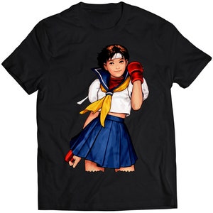 Könnte beinhalten: Schwarzes T-Shirt mit einer bunten Illustration einer weiblichen Anime-Figur, die eine Matrosenuniform und rote Boxhandschuhe trägt. Die Figur hat rote Haare und hält einen roten Boxhandschuh in ihrer rechten Hand.
