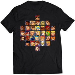 Op de afbeelding: Zwart T-shirt met een pixelvormig ontwerp van personages uit de Street Fighter-videogameserie. De personages zijn in een ruitvorm gerangschikt.