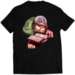 Puede incluir: Una camiseta negra con un gráfico de un mono con gafas leyendo un libro. El mono lleva una túnica verde y marrón.