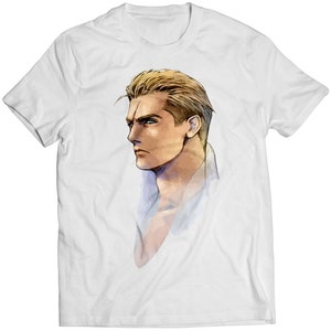 Puede incluir: Una camiseta blanca con un gráfico de un hombre con cabello rubio y una expresión seria. El hombre está mirando hacia la izquierda de la imagen.