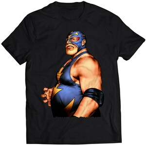 Könnte beinhalten: Schwarzes T-Shirt mit einem Grafikdruck eines Wrestlers, der eine blaue und gelbe Maske und einen blauen Wrestling-Overall trägt.