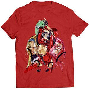 May include: Red t-shirt with a graphic print of three women in a fighting pose. The women are wearing red, black, and white clothing. The graphic is in a comic book style.