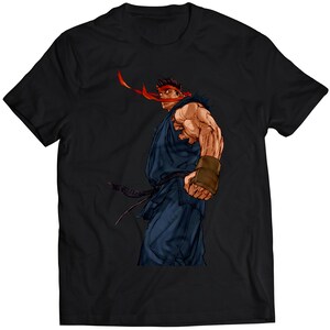 Könnte beinhalten: Ein schwarzes T-Shirt mit einem Aufdruck eines muskulösen Anime-Charakters, der ein blaues Gi und ein rotes Stirnband trägt. Der Charakter ist vom Betrachter abgewandt und hat einen entschlossenen Ausdruck.