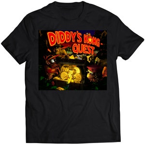 Puede incluir: Camiseta negra con una imagen colorida de Diddy Kong del videojuego Diddy's Kong Quest. La imagen muestra a Diddy Kong y otros personajes de pie frente a un cofre del tesoro.