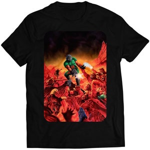 May include: Black t-shirt featuring a vibrant graphic of a futuristic soldier battling demons in a fiery landscape. The design showcases a green-armored figure firing a weapon, surrounded by red creatures and a hellish environment.