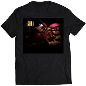 Puede incluir: Una camiseta negra con un gráfico de dos monos en una habitación oscura. El mono de la izquierda lleva una gorra roja y el mono de la derecha lleva un sombrero rosa. Los monos miran al espectador.