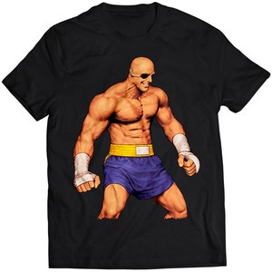 Könnte beinhalten: Schwarzes T-Shirt mit einem Motiv eines kahlköpfigen Mannes in einem gelben und blauen Box-Outfit und einem Augenklappen.