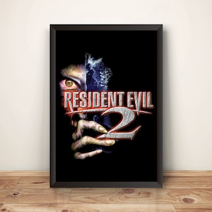 May include: A black framed poster featuring a zombie-like face peering out from behind a torn piece of paper. The text "RESIDENT EVIL 2" is in red and silver on the poster.