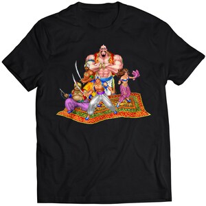 May include: A black t-shirt featuring a graphic print of five characters from a video game. The characters are standing on a magic carpet. The characters include a large, muscular man with a beard, a woman with long, dark hair, and three men with swords.
