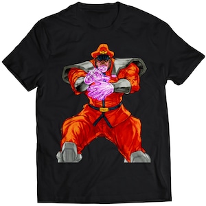 Könnte beinhalten: Schwarzes T-Shirt mit einer Cartoon-Illustration eines rot gekleideten Charakters mit rotem Hut und einer lila Aura um die Hände.