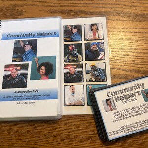 Puede incluir: Se muestra un libro interactivo y tarjetas de tareas tituladas "Community Helpers". El libro tiene una encuadernaci&oacute;n en espiral y presenta im&aacute;genes de ayudantes comunitarios. Las tarjetas de tareas ofrecen actividades de emparejamiento. El texto del libro dice: "Un libro interactivo dise&ntilde;ado para ayudar a los estudiantes a identificar a los ayudantes comunitarios y practicar la palabra 'ayuda'."