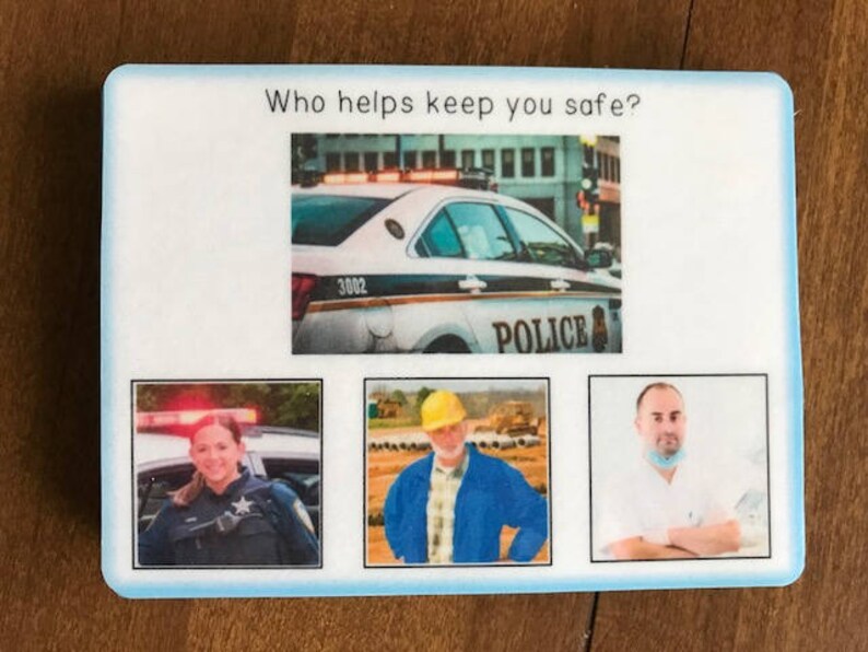 Puede incluir: Un letrero rectangular blanco con el texto "&iquest;Qui&eacute;n te ayuda a mantenerte seguro?" e im&aacute;genes de un coche de polic&iacute;a, un oficial de polic&iacute;a, un trabajador de la construcci&oacute;n y un m&eacute;dico. El coche de polic&iacute;a tiene la palabra "POLIC&Iacute;A".
