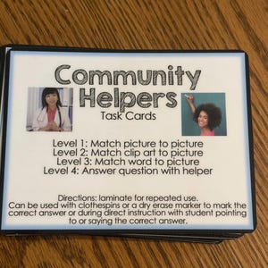 Puede incluir: Una pila de "Tarjetas de tareas de ayudantes comunitarios" con un borde blanco. Las tarjetas presentan im&aacute;genes y texto para actividades de emparejamiento. Se incluyen instrucciones para usar con pinzas o rotuladores.