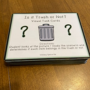 May include: A set of black and white task cards with green borders. The cards have a question mark, a trash can, and the text "Is it Trash or Not? Visual Task Cards". The text "Directions: Student looks at the picture / reads the scenario and determines if each item belongs in the trash or not." is also on the cards. The text "Breezy Special Ed" is at the bottom of the cards.