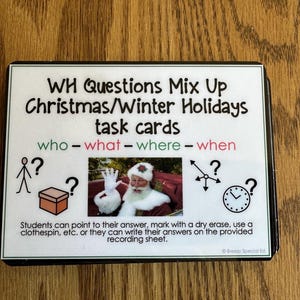 May include: A set of task cards for Christmas and Winter Holidays, featuring the text "WH Questions Mix Up." The cards include illustrations of a stick figure, a gift box, Santa Claus, a clock, and directional arrows. The text reads "who - what - where - when."