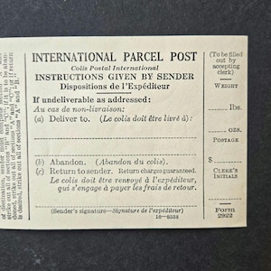 May include: Vintage International Parcel Post form with instructions in English and French. The form includes sections for weight, postage, and clerk's initials. A yellow pencil rests on the right side of the form.