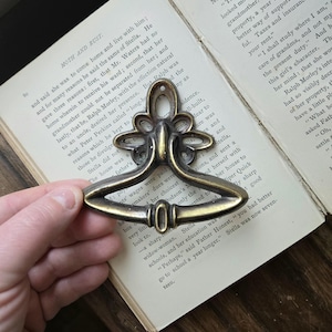 May include: A set of three ceramic mugs with a speckled, matte finish. The mugs are in shades of cream, light gray, and dark gray. Each mug has a simple, minimalist design and a rounded handle.